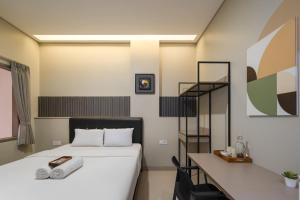 a bedroom with a bed and a desk and a bed sidx sidx sidx at Cove Juanda One in Jakarta