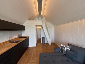 a kitchen and living room with a couch and a staircase at Rhosyn Highland Cattle Farm in Dunstall