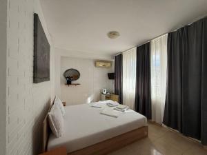 a bedroom with a bed and a large window at Hotel Zora by TM in Ravda