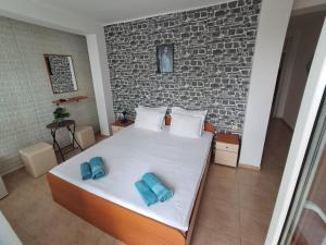 a bedroom with a bed with two blue towels on it at Hotel Zora by TM in Ravda
