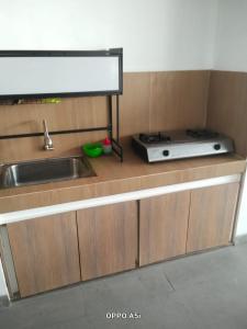 a kitchen with a sink and a microwave on a counter at Dalem Suwarno Baru in Timuran +7 photos