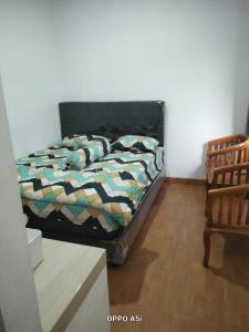 a bedroom with a bed and a chair at Dalem Suwarno Baru in Timuran