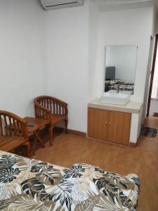 a bedroom with a bed and a mirror and a sink at Dalem Suwarno Baru in Timuran