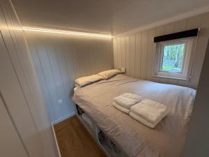 a small bedroom with a bed with towels on it at Rhosyn Highland Cattle Farm in Dunstall