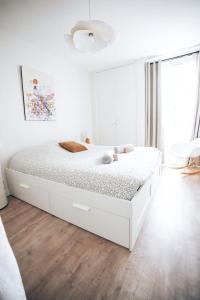 a white bedroom with a white bed in a room at La bulle canetoise - vue mer in Canet-en-Roussillon
