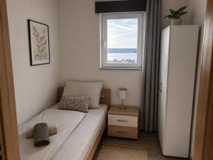 a small bedroom with a bed and a window at Apartments Ana in Gornji Karin