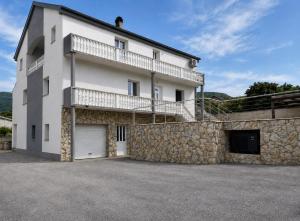 a large white building with a stone wall at Apartments Ana in Gornji Karin