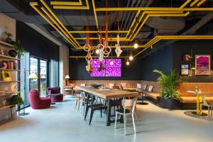 a dining room with a large table and chairs at Moxy Budapest Downtown in Budapest