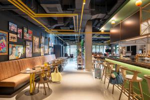 a restaurant with tables and chairs and a bar at Moxy Budapest Downtown in Budapest
