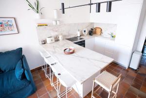 a kitchen with a white marble table and chairs at La bulle canetoise - vue mer in Canet-en-Roussillon