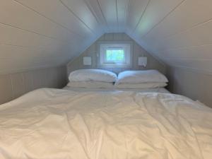 a white bed in a room with a window at Rhosyn Highland Cattle Farm in Dunstall
