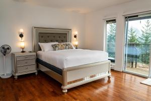 a bedroom with a large bed and two windows at Mountain Retreat Hope in Hope