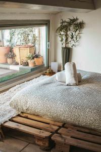 a bedroom with a bed and a window with plants at O Saudade - Centre Perpignan in Perpignan