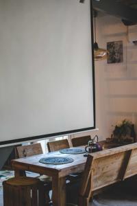 a wooden table with chairs and a large screen at O Saudade - Centre Perpignan in Perpignan