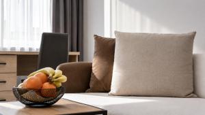 a bowl of fruit on a table in front of a couch at K-49 prie Jūros in Klaipėda