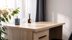 a wooden table with a plant on it next to a window at K-49 prie Jūros in Klaipėda