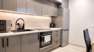 a kitchen with stainless steel appliances and a sink at K-49 prie Jūros in Klaipėda +10 photos
