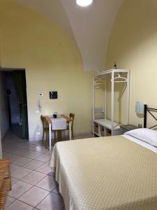 a bedroom with a bed and a table with chairs at Anfiteatro apartment in Formia