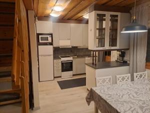 a kitchen with white cabinets and appliances in a room at Aabro, Levi in Kittilä
