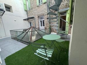 a patio with a table and chairs and a staircase at El Niu - Perpignan hyper centre in Perpignan
