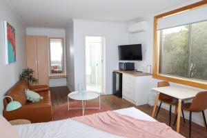 a room with a bed and a table and a tv at Harbour View Motel in Robe