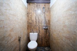 a bathroom with a toilet and a shower at Griya Gribig Guest House Mitra RedDoorz in Malang +46 photos