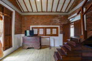 a brick room with a staircase and a brick wall at Griya Gribig Guest House Mitra RedDoorz in Malang