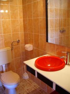 a bathroom with a red sink and a toilet at Bolyarski Stan Guest House in Veliki Preslav