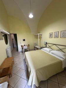 a bedroom with a large bed and a table at Anfiteatro apartment in Formia +3 photos
