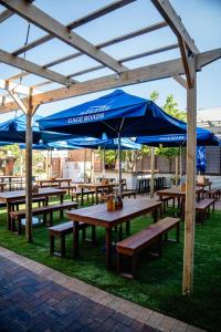 a group of picnic tables with blue umbrellas at Rec Toodyay Hotel in Toodyay
