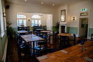 a restaurant with wooden tables and chairs in a room at Rec Toodyay Hotel in Toodyay