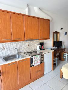 a kitchen with wooden cabinets and a sink at Calm Paros in Logaras +1 photo