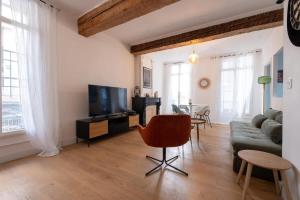 a living room with a couch and a tv and a table at Le Cocon d'Or Perpignan Centre in Perpignan