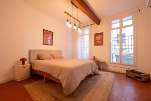 a bedroom with a bed and a large window at Le Cocon d'Or Perpignan Centre in Perpignan