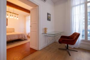 a bedroom with a desk and a bed and a chair at Le Cocon d'Or Perpignan Centre in Perpignan
