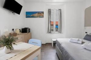 a bedroom with a bed and a table and a tv at Domi Home in La Spezia