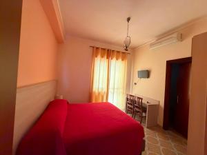 a bedroom with a red bed and a window at Albergo Maria Cristina in Esperia