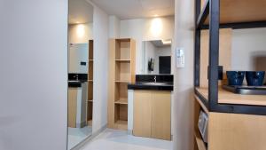 a kitchen with wooden cabinets and a sink at Casa Mysa Hotel Kuta in Kuta