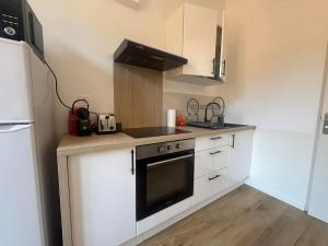 a kitchen with white cabinets and a stove top oven at Le Nomad - Perpignan center in Perpignan