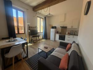 a living room with a couch and a table and a kitchen at Le Nomad - Perpignan center in Perpignan
