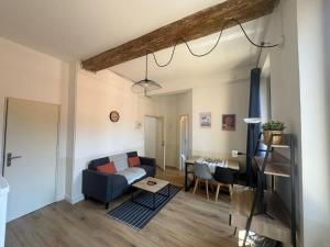 a living room with a blue couch and a table at Le Nomad - Perpignan center in Perpignan