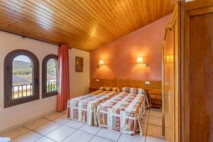a bedroom with a bed and a wooden ceiling at Els Castellers in Sant Pau dʼOrdal +18 photos