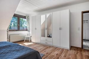 a bedroom with white cabinets and a bed at Storchenallee in Burg