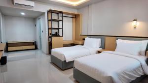 a hotel room with two beds and a desk at Casa Mysa Hotel Kuta in Kuta +19 photos