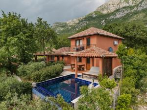 an image of a house with a swimming pool at Harmonia Bungalows & Pool in Sveti Stefan