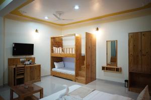 a bedroom with two bunk beds and a tv at Hotel Arijika View in Kullu Manali