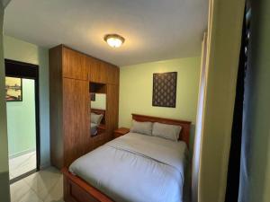 a bedroom with a bed with a wooden headboard at JK properties in Kampala