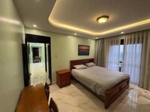 a bedroom with a bed and a table and chairs at JK properties in Kampala