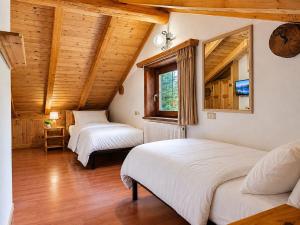 three beds in a room with wooden ceilings at Hotel Aquila in Livigno