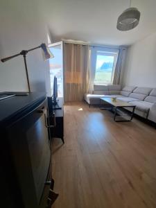 a living room with a couch and a tv at Apartmán JAMI REZIDENCIA in Spišské Podhradie